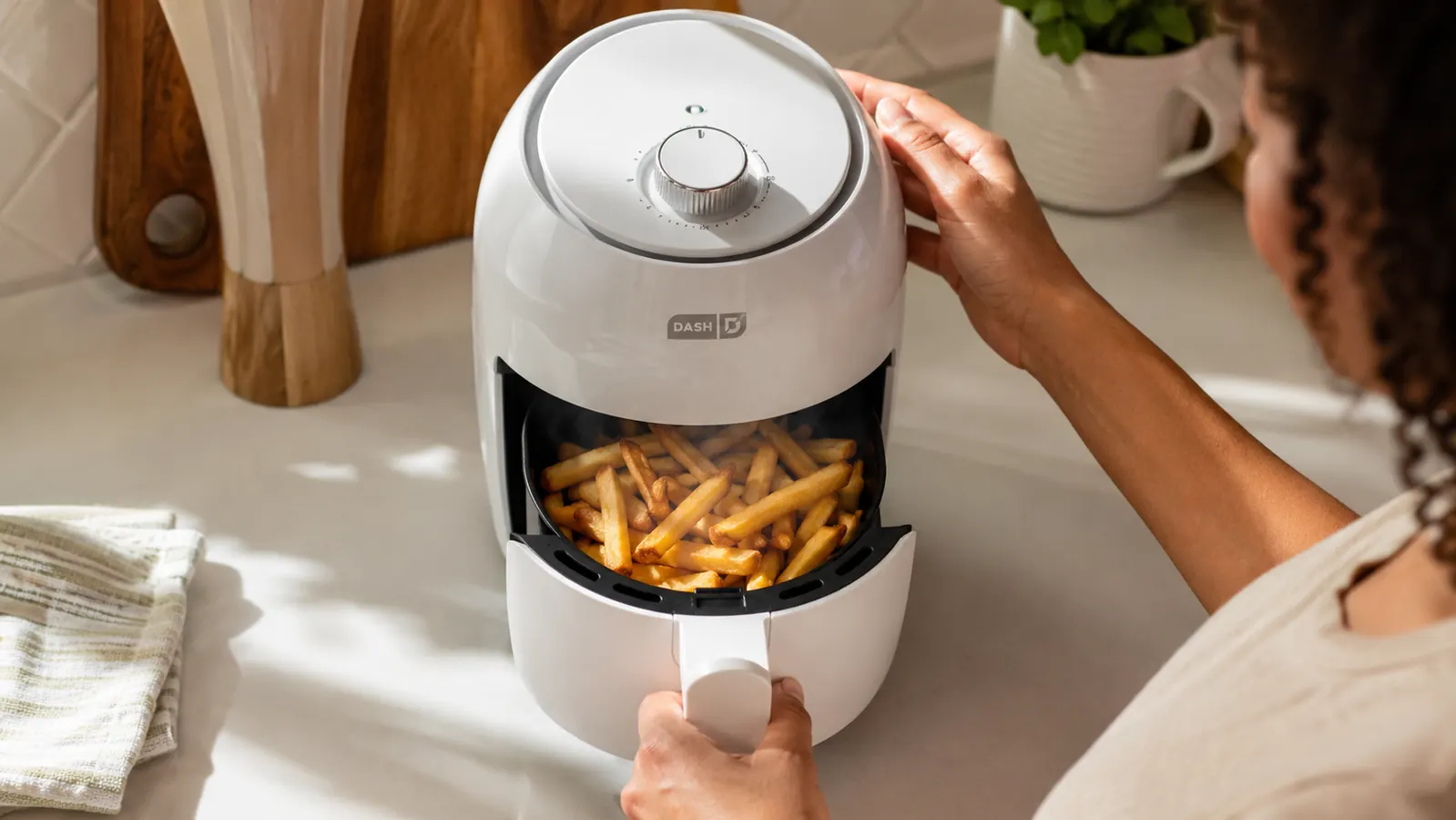 Golden crispy french fries in the Dash air fryer basket fresh out of cooking