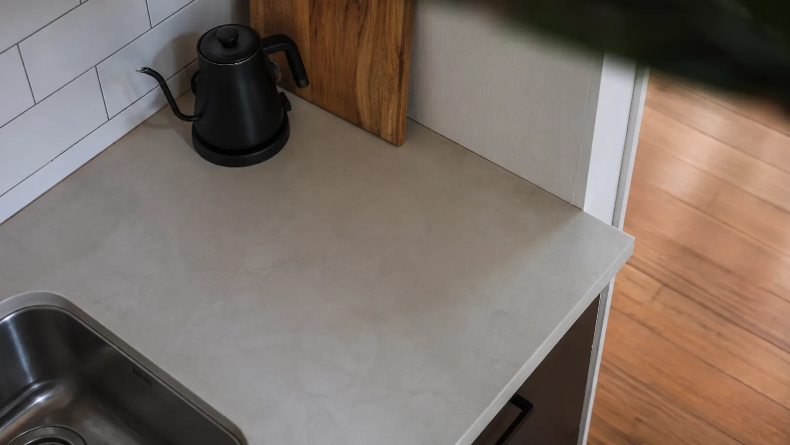 A small kitchen counter with only the Cosori kettle and a cutting board visible, showing how little counter space it takes